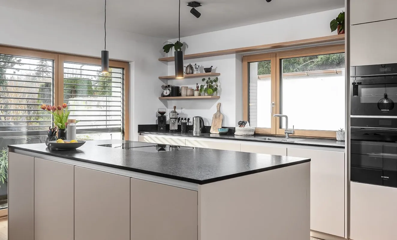 Landhausküche in Taupe/Sandbeige mit Arbeitsplatte aus Granit schwarz von Dan Küchen