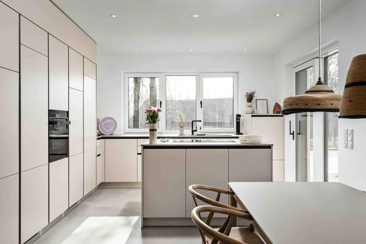 Moderne Küche mit Kochinsel in Matt Creme/Beige mit Arbeitsplatte aus Betonoptik von Dan Küchen