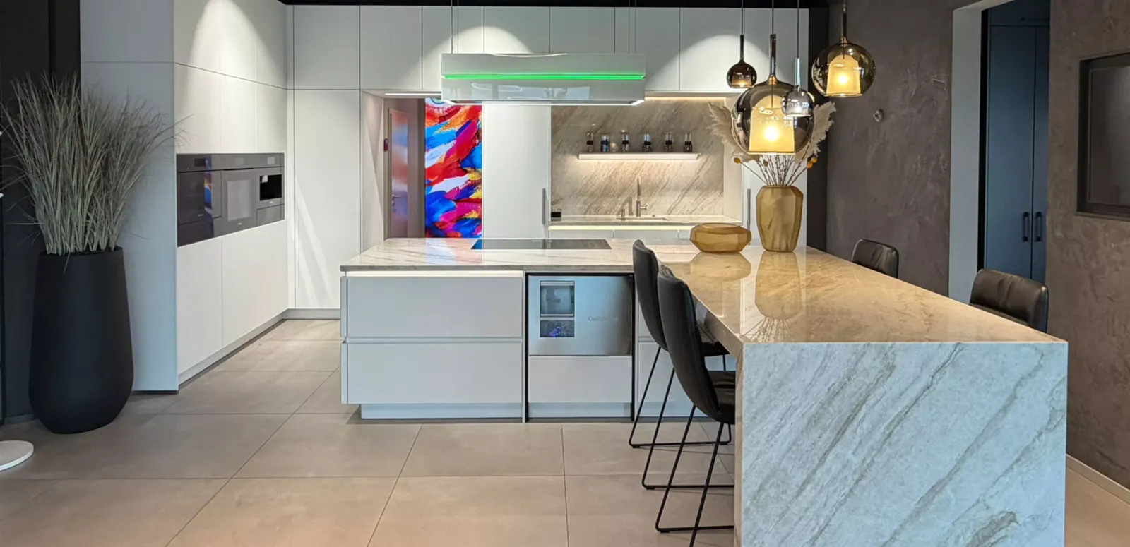 Inselküche mit Fronten aus Organic Glas, Naturstein-Arbeitsplatte und Elektrogeräten in Heidelberg von Plana