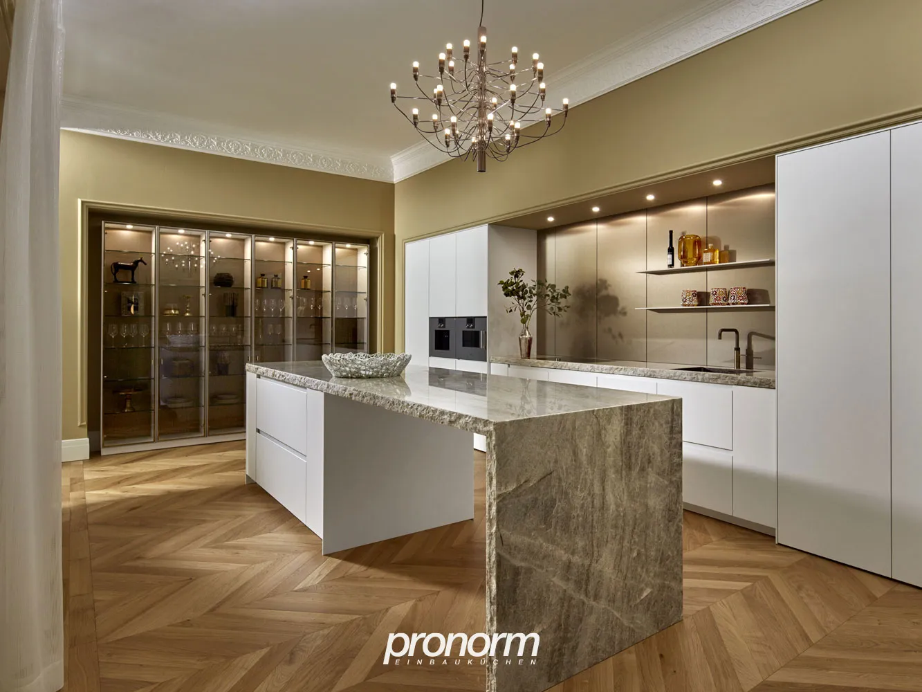 Moderne Küche mit Kochinsel in Weiß matt mit Naturstein-Grau, Arbeitsplatte aus Keramik hellbeige steinoptik von Pronorm