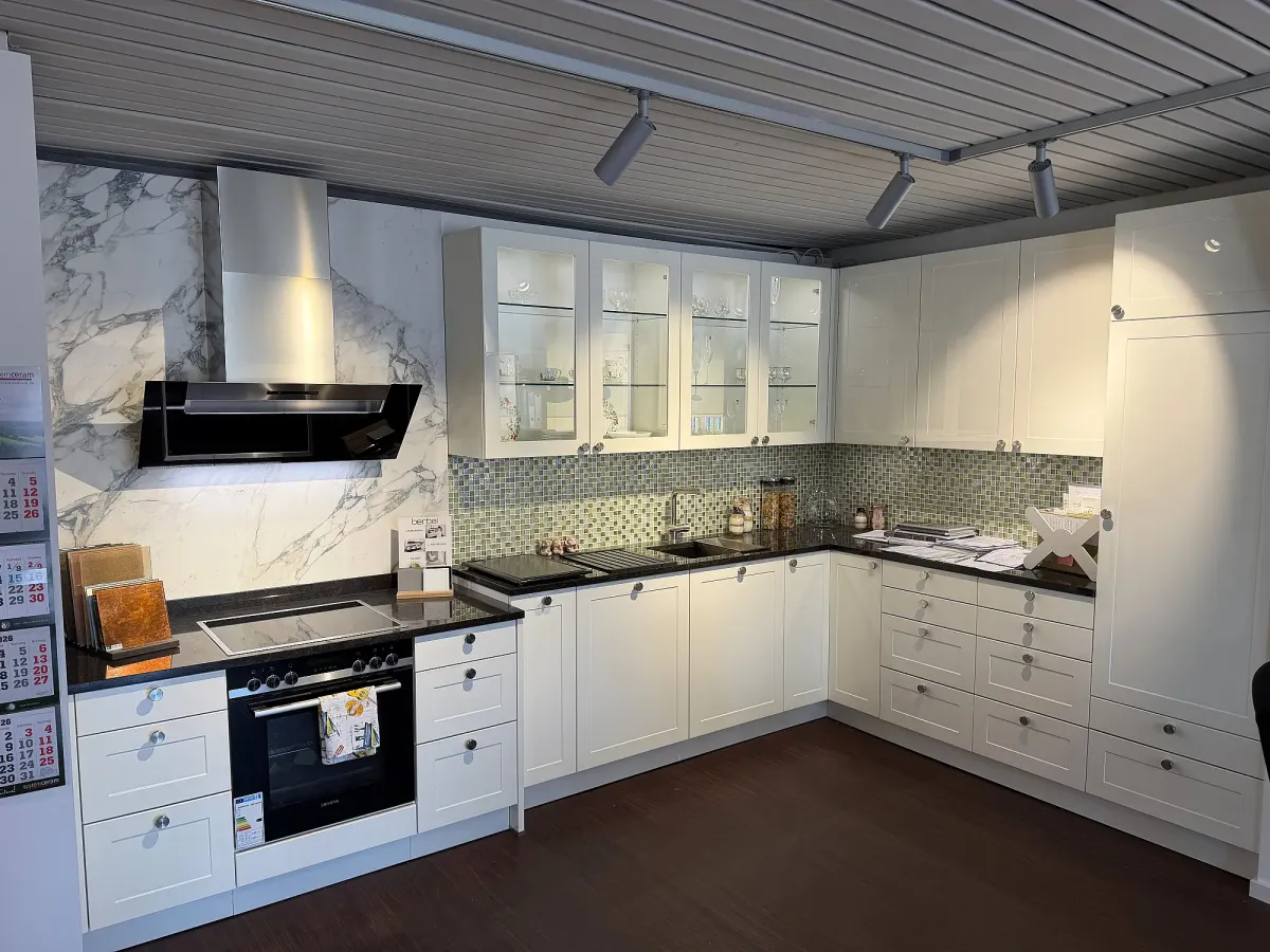 Häcker Landhausküche mit weißen Rahmenfronten und Vitrinen