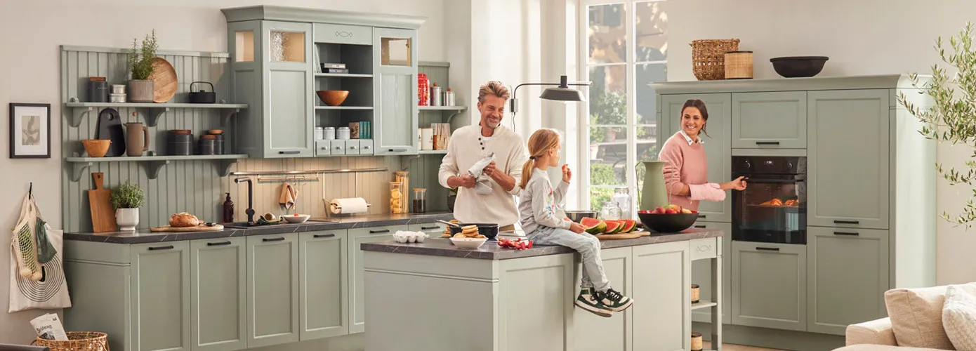 Küche mit Kochinsel im Landhaus-Stil, salbeigrüne Fronten – Hero-Bild der Seite